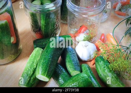 A table with cucumbers, carrots, garlic and dill to be pickled Stock Photo