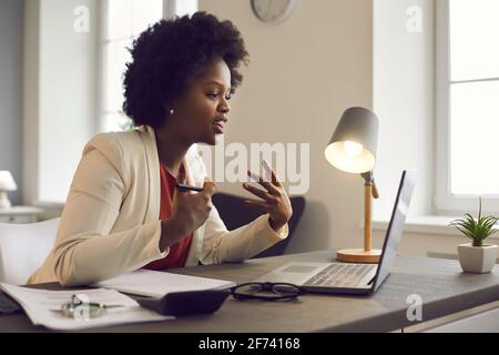 Young african american woman having conference video call via laptop in office Stock Photo