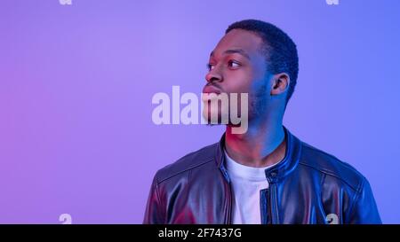 Portrait Of Stylish African American Guy In Leather Jacket Under Neon Light Stock Photo