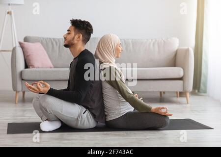 Yoga for Pregnancy and Childbirth. Expecting islamic spouses meditating together at home Stock Photo