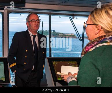 The captain of the Armorique Erwan Fournis on the navigating bridge with journalist Angela Berg Stock Photo