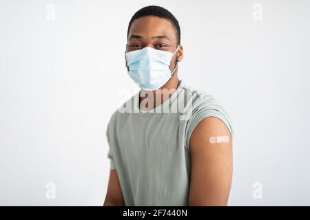 Portrait Of Vaccinated African Guy Wearing Face Mask, White Background