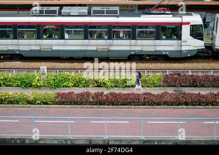 Light rail train, sidewalk and cycle track in Tuen Mun, Hong Kong Stock Photo