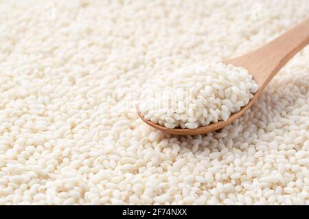 A wooden spoon on top of glutinous rice spread over the entire screen. Close-up photo Stock Photo