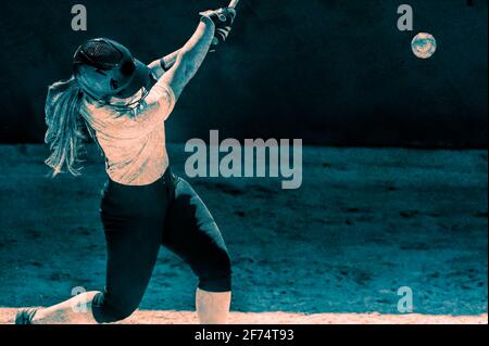 A Female Baseball Player is Swinging Her Bat for the Fences In Tournament Play Stock Photo