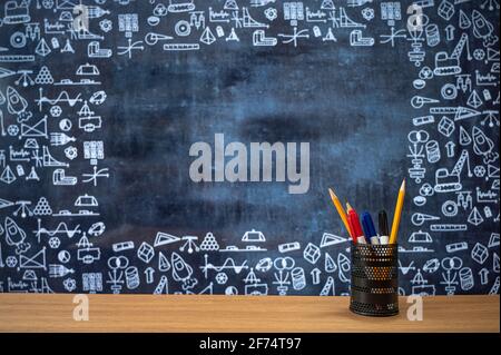 Blackboard with hand-drawn math-related icons. Pencil case on the desk. Education concept. Stock Photo