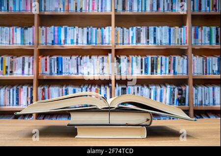 Blurred bookshelves and books on the desk. Education concept. Stock Photo