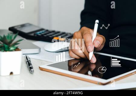 Man using  digital tablet or work on table, icon graph  business concept. Stock Photo