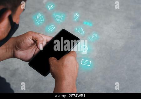 Hand holding smartphone with icons concept. Hand use smartphone online shopping Social media network concept. Stock Photo