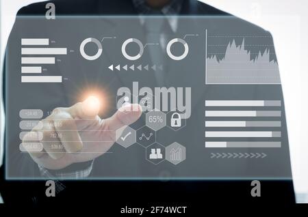 businessman touch screen digital icon graph and chart. business on virtual screen and technology concept. Stock Photo