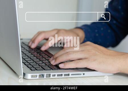 business man hand using a laptop keyboard is searching for information on the internet, social networks. Stock Photo