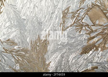 Winter snowy frosty patterns on the glass window. Winter magic. Frosty wonders. Abstract patterns. Stock Photo