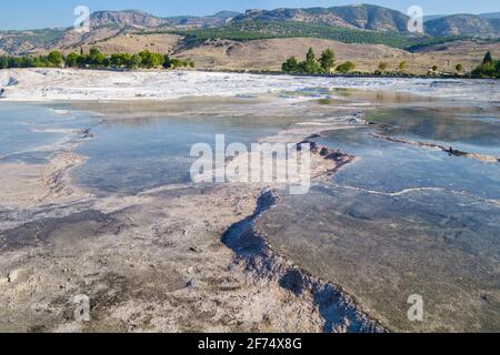 Panoramic view onto far part of Pamukkale reserve, Turkey. Some of terraces have natural color, some are classic white