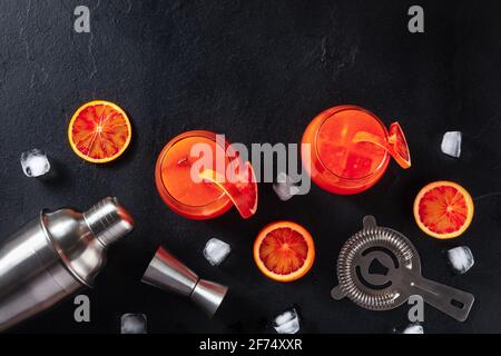 Orange cocktails with blood oranges, a shaker, a jigger, and a strainer Stock Photo