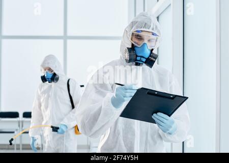 employee of the sanitary service making an entry in the clipboard. Stock Photo