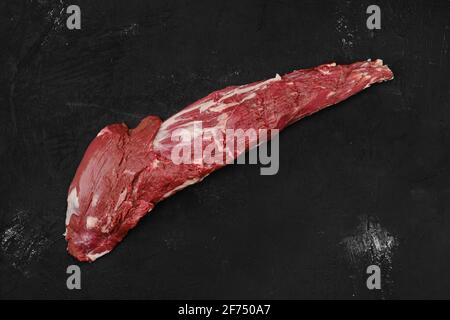 Overhead view of raw beef tri-tip loin on black background Stock Photo
