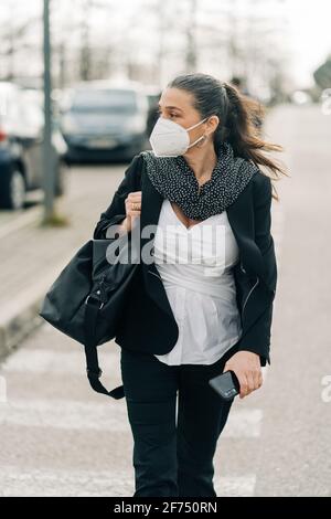 Focused female radio host with mic and headphones writing in notepad while preparing for recording podcast at home Stock Photo