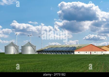 Modern dairy farm using renewable energy, solar panels and wind turbines Stock Photo