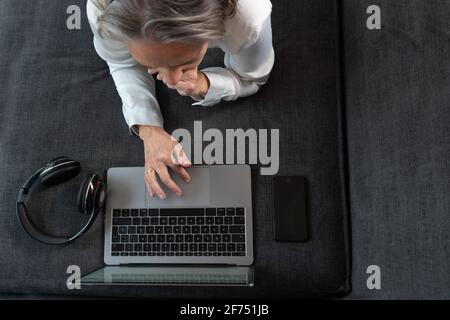 Aged stylist washing hairs of attractive lady near sink in hairdressing salon Stock Photo