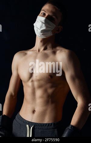 portrait of sportsman wearing boxing gloves and medical mask close-up  Stock Photo