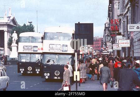 1970s street scene with busses at a bus stop in busy O'Connell Street, Dublin, Ireland Stock Photo