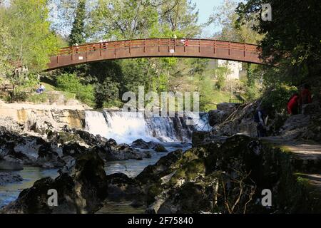 Wooden footbridge over the river Pas in Puente Viesgo Cantabria Spain on a sunny Easter Sunday afternoon from the tourist footpath by the river Stock Photo