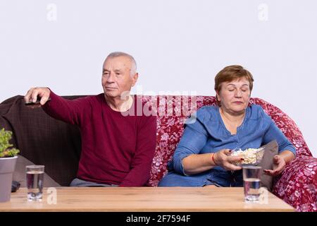 Happy senior couple preparing to watch a movie at home. Stock Photo