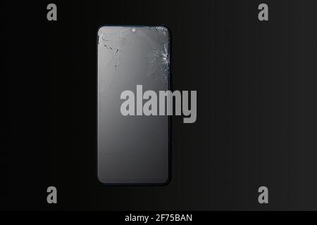 Modern touchscreen smartphone with broken screen on dark background Stock Photo