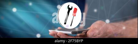 Maintenance service concept above a smartphone held by a man Stock Photo