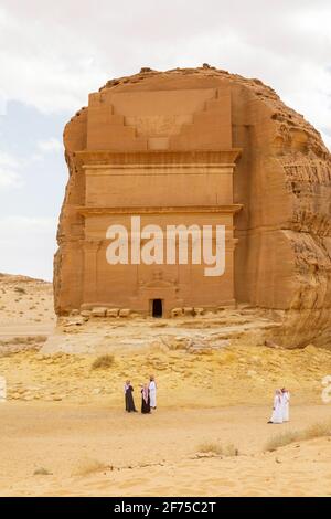 AlUla, Saudi Arabia, February 19 2020: Tourists from Saudi Arabia stand with ther guides in front of the tomb of Lihyan son of Kuza, known as Qasr AlF Stock Photo