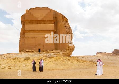 AlUla, Saudi Arabia, February 19 2020: Tourists from Saudi Arabia stand with ther guides in front of the tomb of Lihyan son of Kuza, known as Qasr AlF Stock Photo