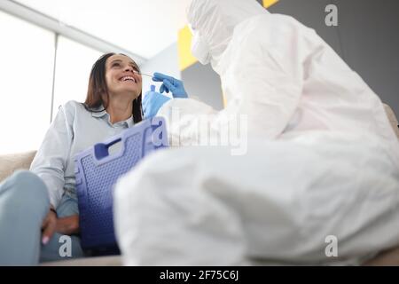 Doctor in protective suit taking swab for coronavirus from patient Stock Photo