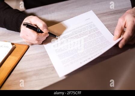 Senior businessman reviewing terms of contract at office Stock Photo