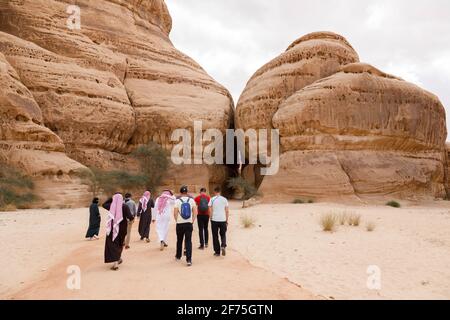 Al Ula, Saudi Arabia, February 19 2020: Tourists run to the entrance of the Siq Jabal Ithlib in Al Ula, KSA Stock Photo