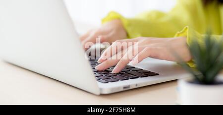 Closeup of hand young asian businesswoman working on laptop computer on desk at home office, freelance looking and typing on notebook on table, woman Stock Photo
