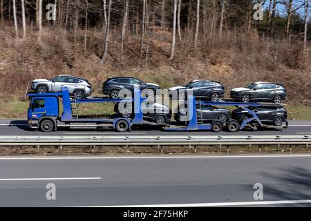 Rimo car-carrying Scania truck loaded with new cars on motorway. Stock Photo