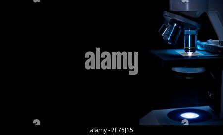 Microscope in labor in dark blue  light  and black background. Stock Photo