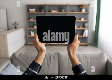Male Hands Holding Tablet With Blank Screen Standing At Home Stock Photo