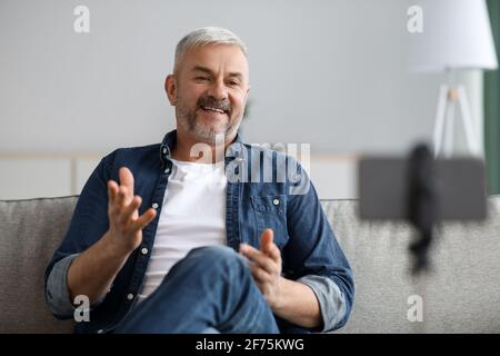 Happy handsome senior man broadcasting from home Stock Photo