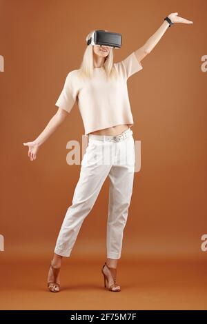 Slim pretty young woman dancing and performing with virtual reality glasses on Stock Photo