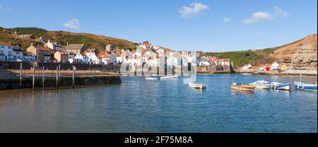 Sunny summer view across the harbour towards the attractive fishing village of Staithes on the Yorkshire coast Stock Photo