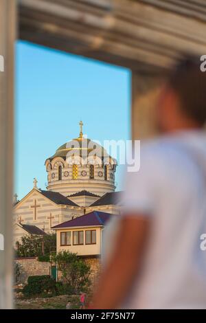 Ukraine, Crimea, Sevastopol, Ancient City of Khersoness, Tourist looking at St Vladimir's Cathedral through ancient gate Stock Photo