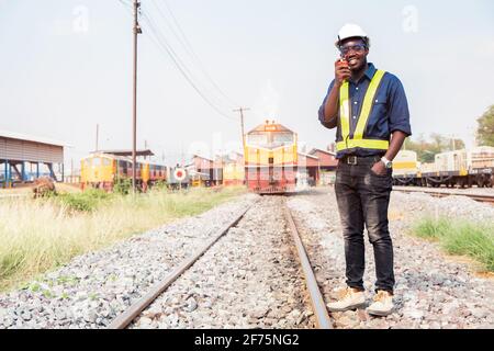 African engineer   control a the train on railway with talking by radio communication or walkie talkie Stock Photo