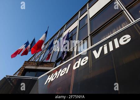 Exterior view of a French town hall with flags and the word 'Hôtel de ville' (meaning 'town hall') written in French on the facade Stock Photo