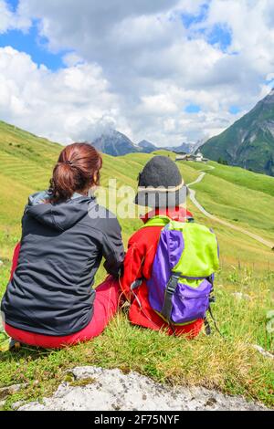 Woman hiking with a group of children in the alpine region around Warth /Arlberg Stock Photo