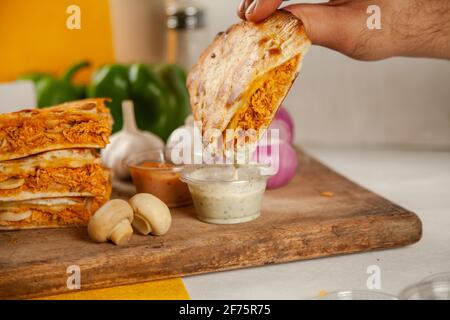 Chicken stuffed naan with white dipper sauce local desi pizza food. Stock Photo