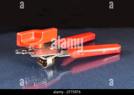 Manual mechanism with red handle on black background.rolling machine for glass jars Stock Photo