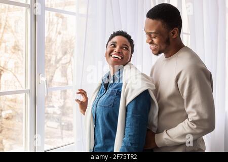 African american couple standing near glass window indoors Stock Photo