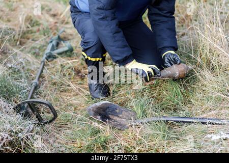 A man in a special suit works with a detector and found an explosive device. Stock Photo