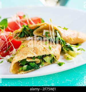 Omelette rolls on a plate. Homemade fried omelet rolls with chopped greens. Healthy low carb recipe. Stock Photo